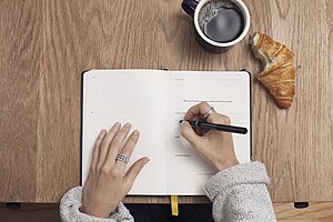 Writing in a journal (Unsplash)